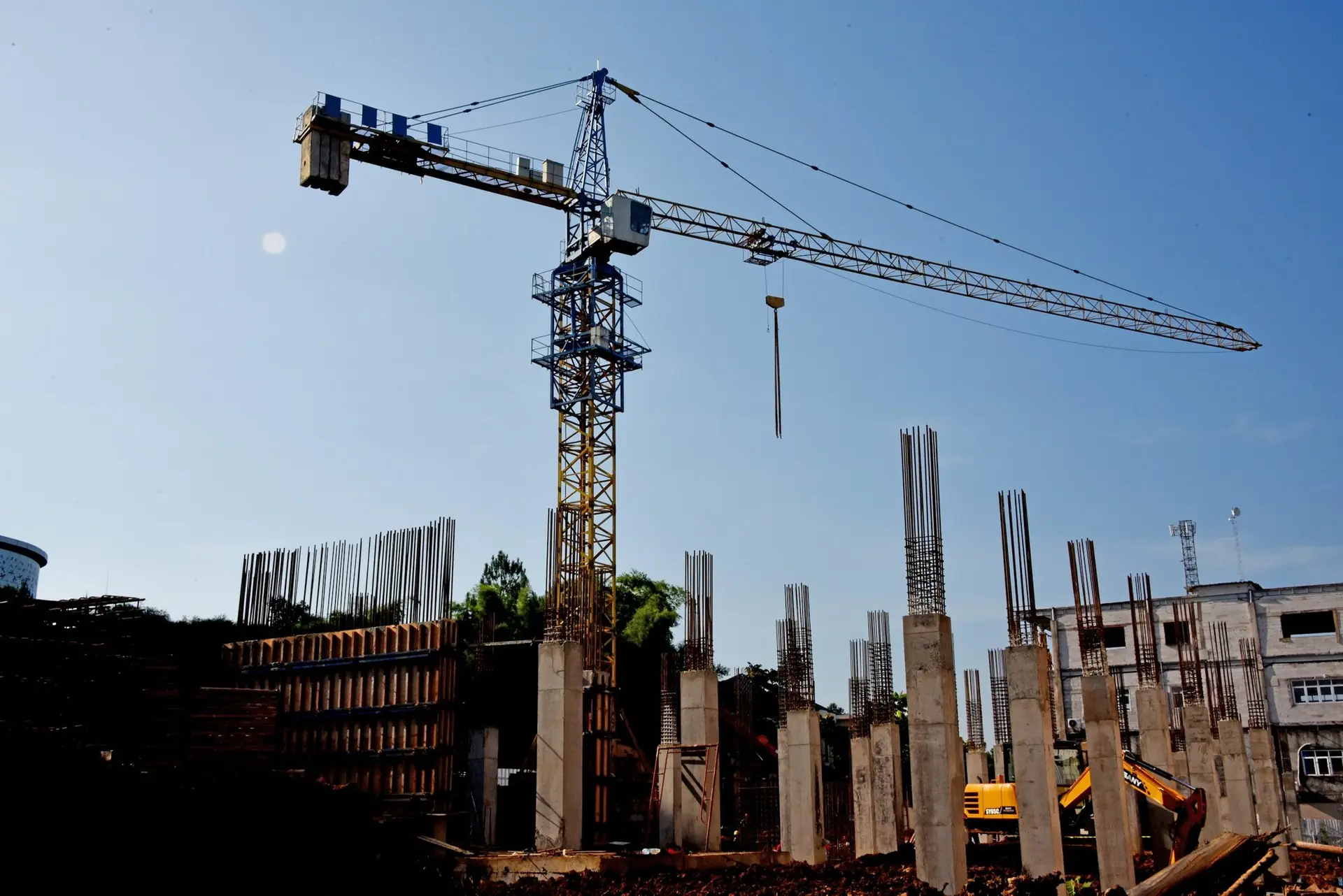 Poteaux en béton et grue à tour sur un chantier en cours
